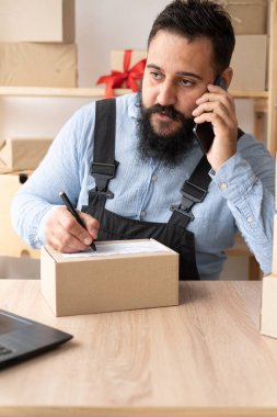 Küçük işletme hevesli Hintli girişimci, merkez ofiste bilgisayar ve akıllı telefon, çevrimiçi pazarlama paketleme kutusu teslimatı, KOBİ tele pazarlama kavramı kullanarak çalışan küçük ve orta büyüklükteki iş adamı