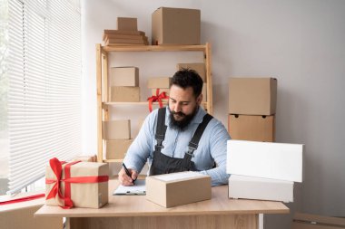 Hintli sakallı iş adamları dizüstü bilgisayarlarını kullanarak evdeki sipariş kutularını kontrol ediyorlar. Küçük işletme girişimcisi KOBİ serbest çalışmaya başlıyor. çevrimiçi pazarlama paketleme kutusu teslimatı, KME kavramı.
