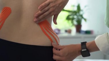 Sırtında ve yanlarında Kinesio bandı olan genç bir kadın. Kinesio karın ve karın bölgesini kaldırmak için bant. Kilo verme konsepti.