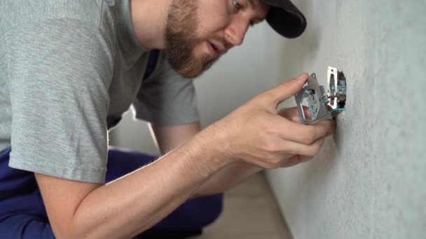 白い壁に電気ソケットを屋内で取り付け 部屋のソケットを交換する電気技師 — ストック動画