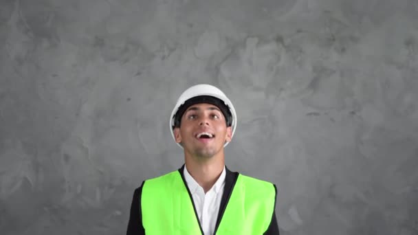 身穿灰色背景制服的阿拉伯男性工业工程师 安全设备 年轻的建筑师穆斯林男子指指点点向上 — 图库视频影像