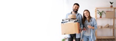 Mutlu çift yeni evde birlikte mal satın alıyor kredi kartı ve akıllı telefon kullanıyor, online ödeme yapıyor, taşınma konsepti, afiş, boş alan