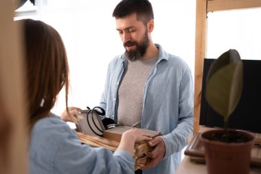 Taşınma günü. Mutlu çift eşyalarını topluyor ve birlikte çalışıyorlar. Taşınırken yardım