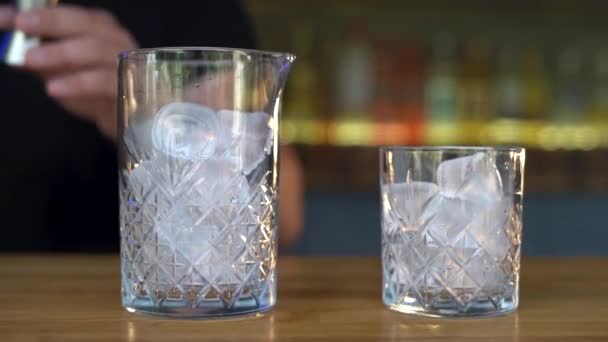 一个男调酒师把伏特加倒入一个装有冰块的鸡尾酒杯中 供夏季饮用 后续行动 — 图库视频影像