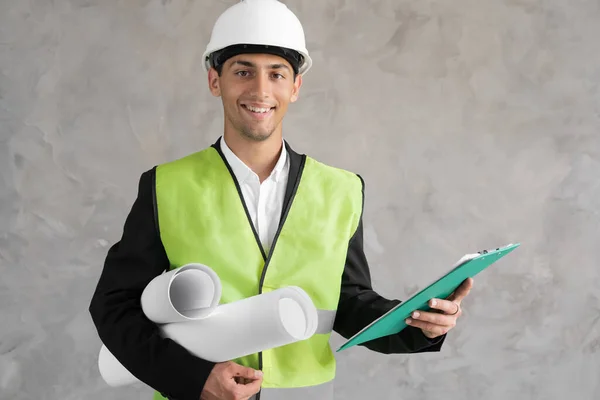 Confident Young Arabic Male Construction Engineer Hardhat Waistcoat Holding Rolled — Stockfoto
