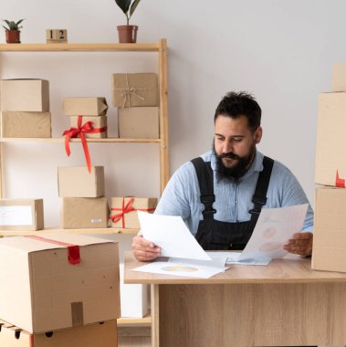 Starting small business, SME owner man entrepreneur prepare to pack the boxes track deliveries and invoices, sell to customers, sme business ideas online.