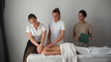 Sağlık masajı eğitimi konsepti. Bir bayan öğretmen el hareketlerini nasıl doğru yapacağını ve genç bir öğrenciye nasıl öğreteceğini gösterir. Boşluğu kopyala.