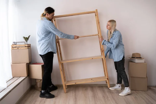 Pareja Feliz Mudándose Nuevo Hogar Poniendo Estante Llevar Nuevos Muebles —  Fotos de Stock