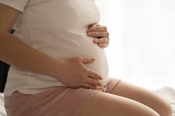 Primer Plano Mujer Embarazada Sentada Cama Tocando Vientre Casa Embarazo — Foto de Stock