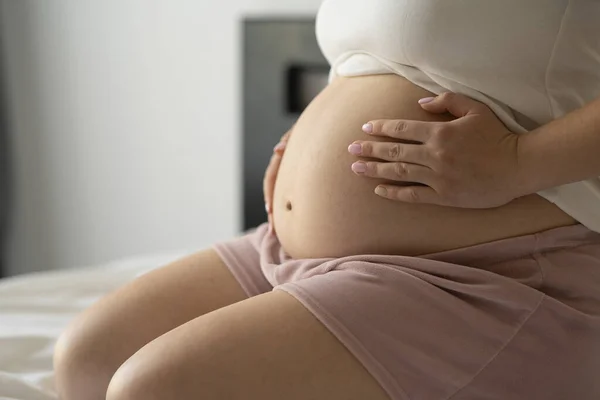 Közel Egy Terhes Nőhöz Aki Ágyon Otthon Fogdossa Hasát Terhesség — Stock Fotó