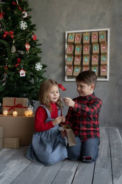 Happy kids with christmas advent calendar craft packs, brother and sister joy from candy pack. Christmas kid's fan concept