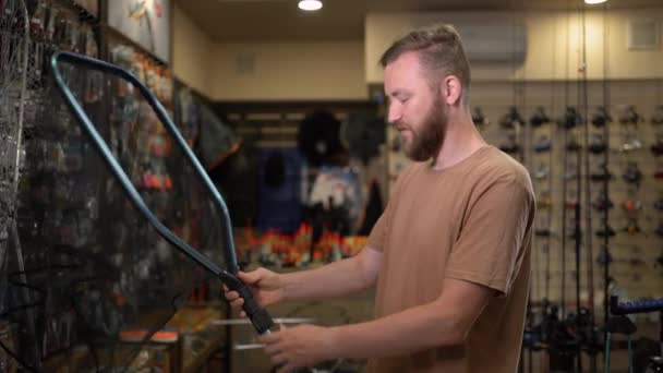 Молодий Бородатий Чоловічий Рибалка Магазині Риболовлі Вибирає Сітку Риболовлі Складає — стокове відео