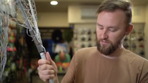 Young Bearded Caucasian Male Fisherman Fish Tackle Shop Chooses Aluminum — Stockvideo