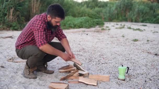 Kemping Przyrodzie Biały Młodzieniec Siada Piasku Układa Drewno Ognisko Koncepcja — Wideo stockowe
