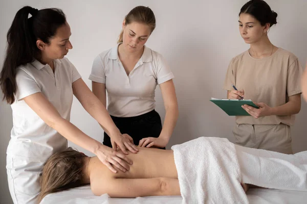 Massage training class, teacher teaches students to become a masseuse, health wellness massage training concept