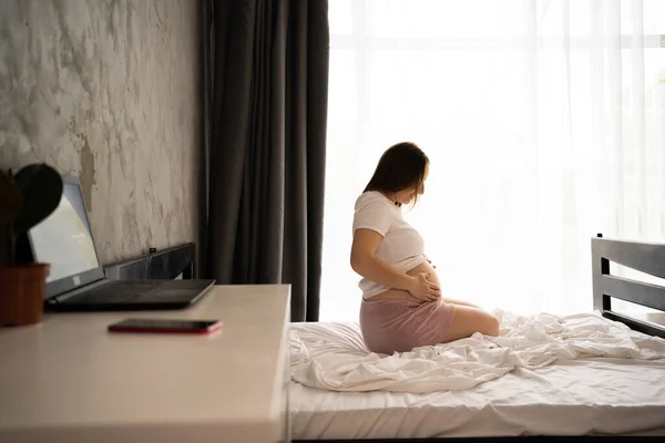 Attractive Pregnant Woman Sitting Bed Holding Her Belly Bedroom Window — стоковое фото