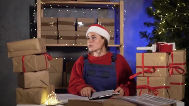 Small Business Worker Dressed Santa Claus Marks Goods Warehouse Counts — Stok Video