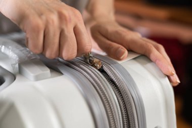 Close up of zipping grey travel suitcase luggage, selective focus.
