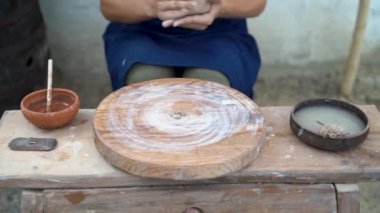 Çömlekçi kadın, atölyedeki çömlekçide kırmızı kille çalışıyor. Kadın eli bir demlik yaratır. Kil yakın plan modelleme.
