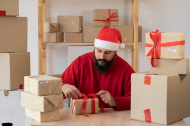 start up small business owner packing cardboard box at workplace. seller Santa Claus prepare parcel box of product for deliver to customer. Online selling, Christmas sale, commerce, shipping concept