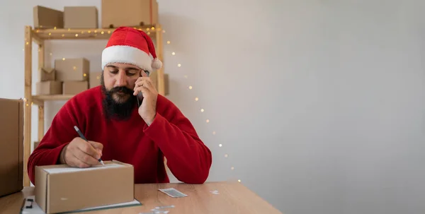 Salesman Santa Claus Hat Takes Order Cell Phone While Sitting — Zdjęcie stockowe