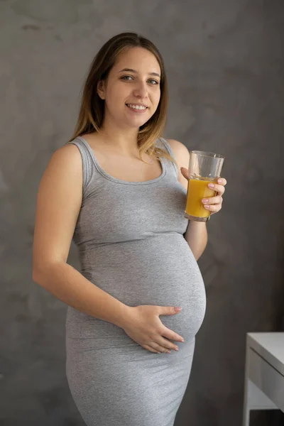 Young Pregnant Woman Holding Glass Orange Juice Home — Zdjęcie stockowe