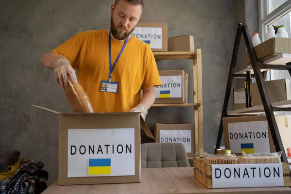 Volunteers collecting food donations in a warehouse, a helping hand to ukraine