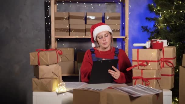 Small Business Worker Dressed Santa Claus Marks Goods Warehouse Counts — Video