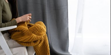 Close-up of woman hands knitting colorful wool yarn. horizontal photo. Freelance creative working and living concept. banner, empty space