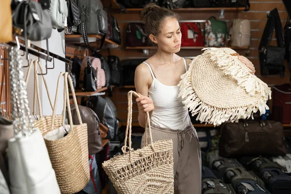 Young Female Shopper Choosing Straw Handbag Matching Her Casual Style — Stok fotoğraf