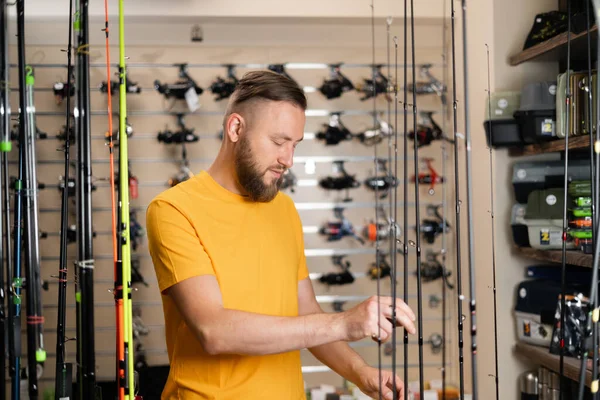 Millennial Man Chooses Fishing Rod Sports Shop Copy Space — Stock fotografie