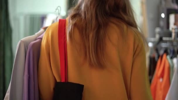 Жінка Вибирає Одяг Жіночому Магазині Одягу Вона Взяла Кілька Варіантів — стокове відео