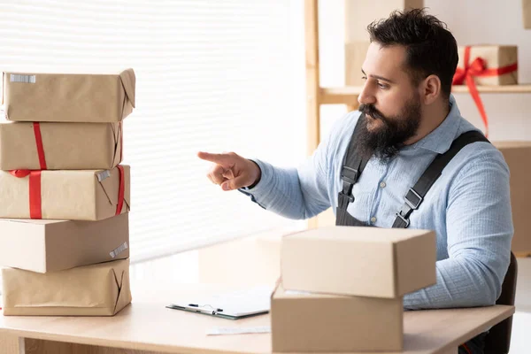 Man online seller checking stock and Inventory before sending to the customer owns a small business. Employee prepares packages for shipment. online marketing packaging box and delivery, SME concept