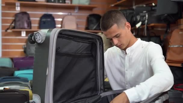 Young Caucasian Man Shirt Chooses Travel Suitcase Haberdashery Store Considers — Video Stock