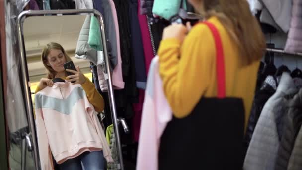 Portrait Lady Choosing Clothes Store Stands Mirror Puts Womens Clothes — Stok Video