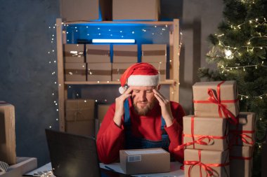 Start up small business entrepreneur SME man in Santa hat working with box at home, frustated stressed small business owner, online marketing packaging Christmas box and delivery, SME stress concept