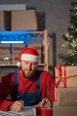 man entrepreneur small business owner is writes adress delivery at home in a small office. Prepares boxes for shipment. Big sale for Christmas. home office is seller of online store. start-up. copy