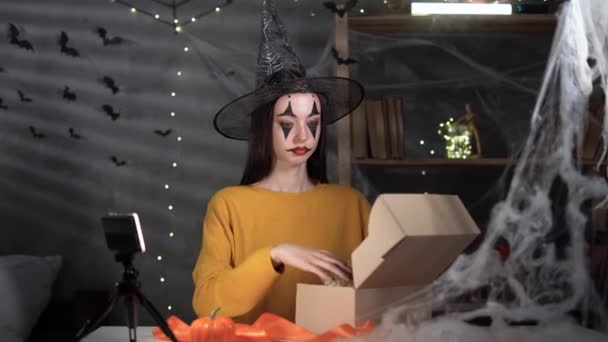 Young Woman Dressed Witch Packing Halloween Gift Box While Sitting — 图库视频影像