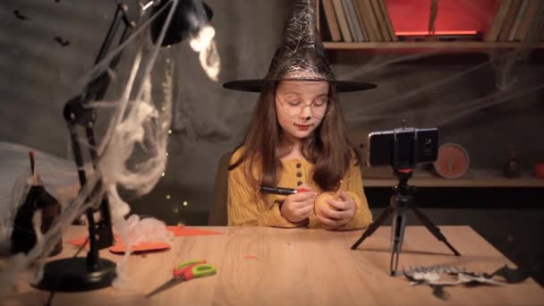 레코딩 즐거운 소녀는 자신의 블로그를 찍으면서 삼각대 스마트폰에 이야기하는 모습을 — 비디오