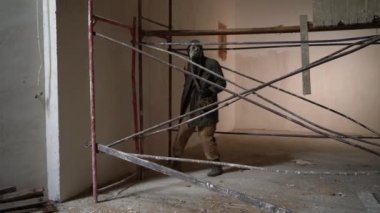 Gaz maskeli ve sırt çantalı bir adam terk edilmiş büyük bir binanın içinden geçiyor borulardan binalara doğru ilerliyor. Kıyamet sonrası dünyada yiyecek arayışında hayatta kalma kavramı..