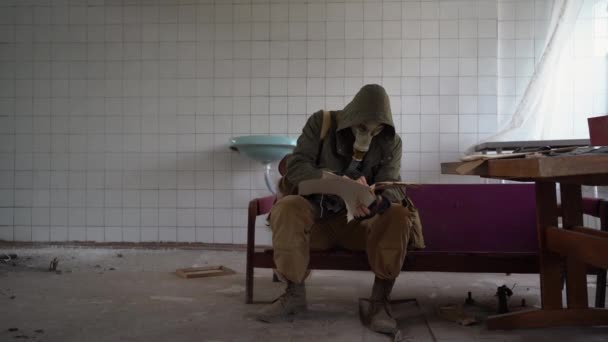 Egy Ember Gázálarcban Egy Régi Esőkabátban Tönkrement Szobában Talál Egy — Stock videók