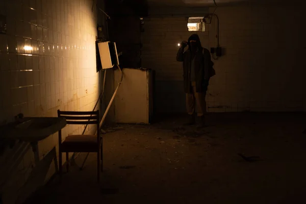 Post Apocalyptic survivor concept, Ruins Apocalyptic abandoned building, a man with flashlight while light on the wall