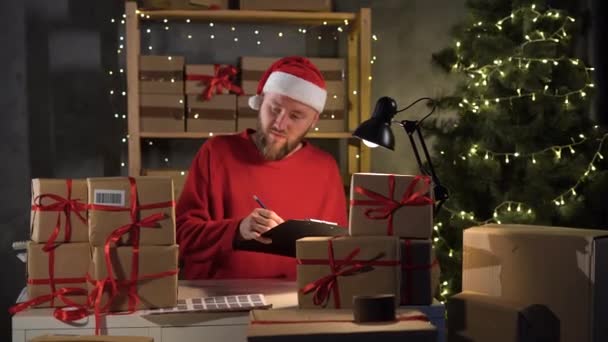 Happy Santa Claus Hat Clipboard Gift Box Sitting Workshop Table — Video