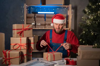 man entrepreneur small business owner is packing goods at home in a small office. Prepares boxes for shipment. Big sale for Christmas. home office is seller of online store. start-up. copy space