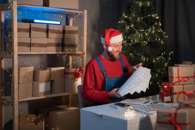 Sevkiyat Çevrimiçi Satış, Küçük işletme veya KOBİ girişimci teslimat servisi ve Noel 'de paketleme kutusu sahibi, iş sahibi Noel Baba postanede doğrulama için kontrol emri veriyor.