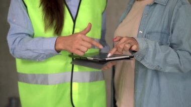 Kadın ve kadın mimar inşaat alanındaki ev planlarını tartışırken dijital tablet kullanıyor. mimari, yapı, inşaat, emlak ve insan konsepti