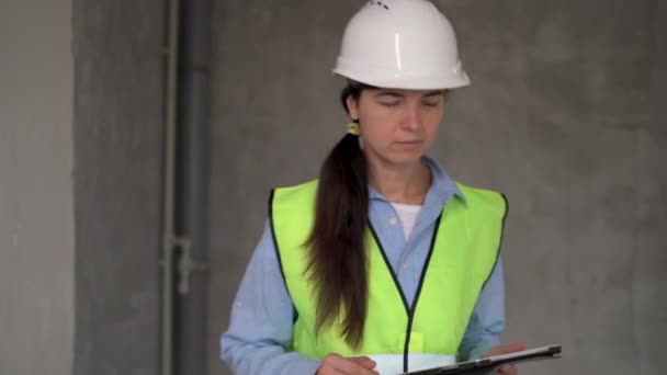 Jonge Vrouwelijke Bouwvakker Projectmanager Met Tablet Een Binnenbouwplaats Kijkend Naar — Stockvideo
