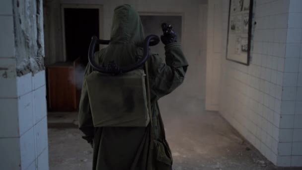 一个戴着防毒面具带着手电筒穿过黑暗建筑的天灾幸存者的背景图 辐射污染 有毒环境 启示录后概念 — 图库视频影像