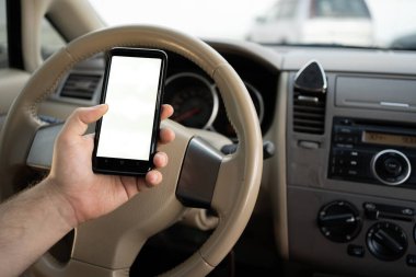 Adam cep telefonu kullanıyor. Navigator uygulaması üzerinden adresi kontrol ediyor. Araba kullanıyor. Sürücü elinde akıllı telefon beyaz ekran modeli tutuyor. Boşluğu kopyala