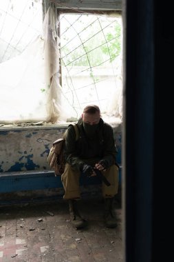 Silahlı kıyamet sonrası hayatta kalan yorgun: çevre felaketi, suç ve savaş konsepti